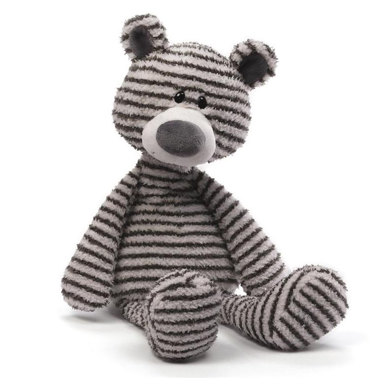 Gray teddy bear with black horizontal stripes in a sitting position. Teddy bear has black button eyes, white snout and a gray nose. 